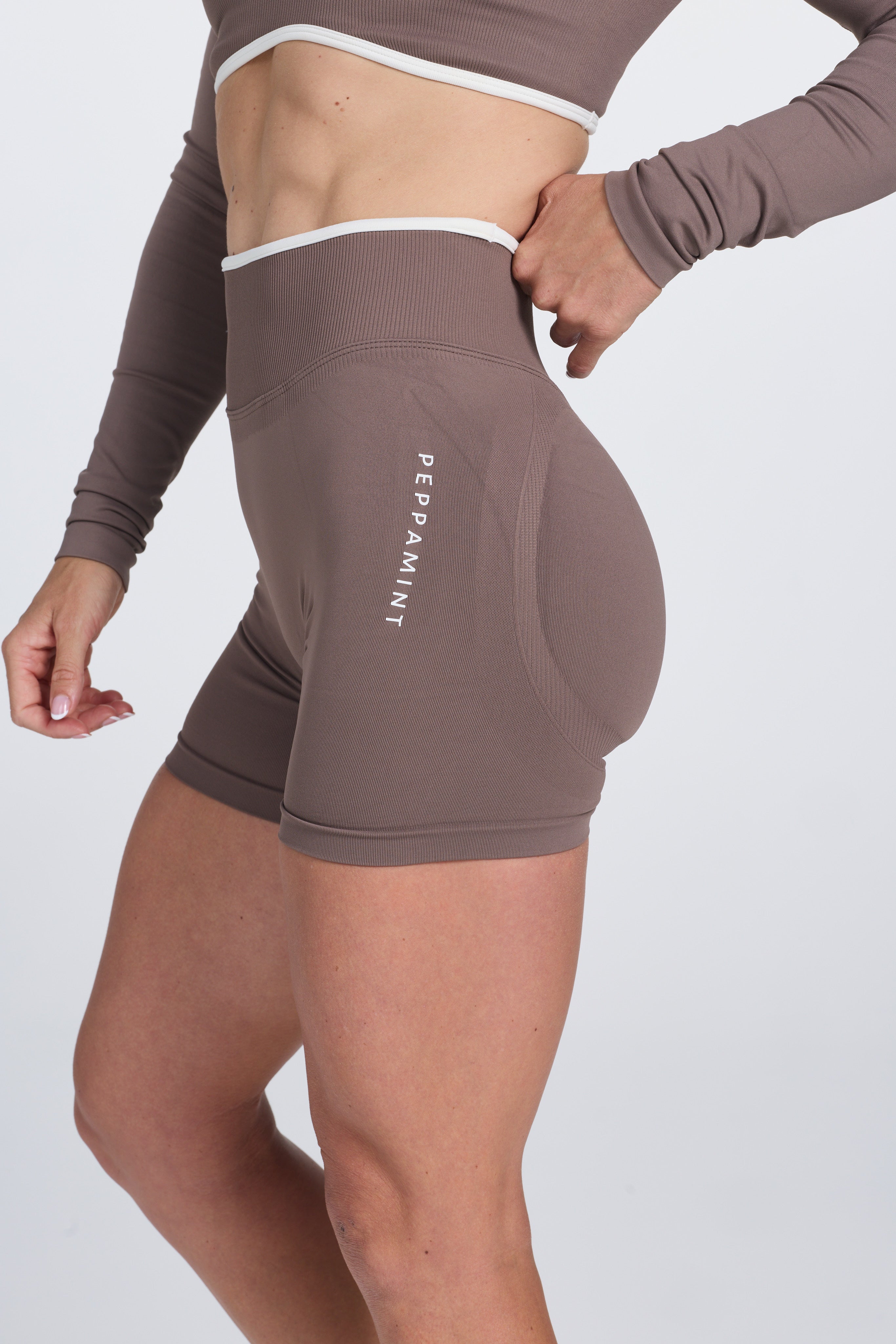 High waisted booty sculpting gym shorts, with textured contouring panels and a luxe white trim with PEPPAMINT branded down the upper thigh, in Mocha colour.