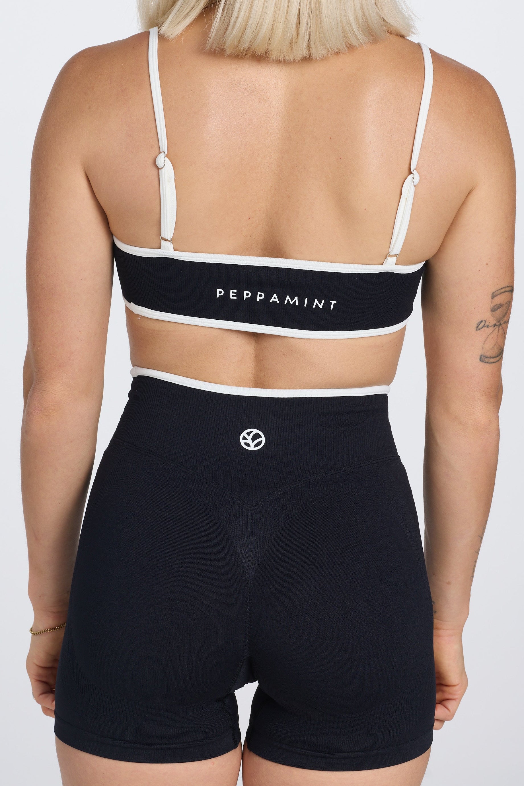 Seamless gym bra, with luxe white trim and adjustable back straps in black colour.