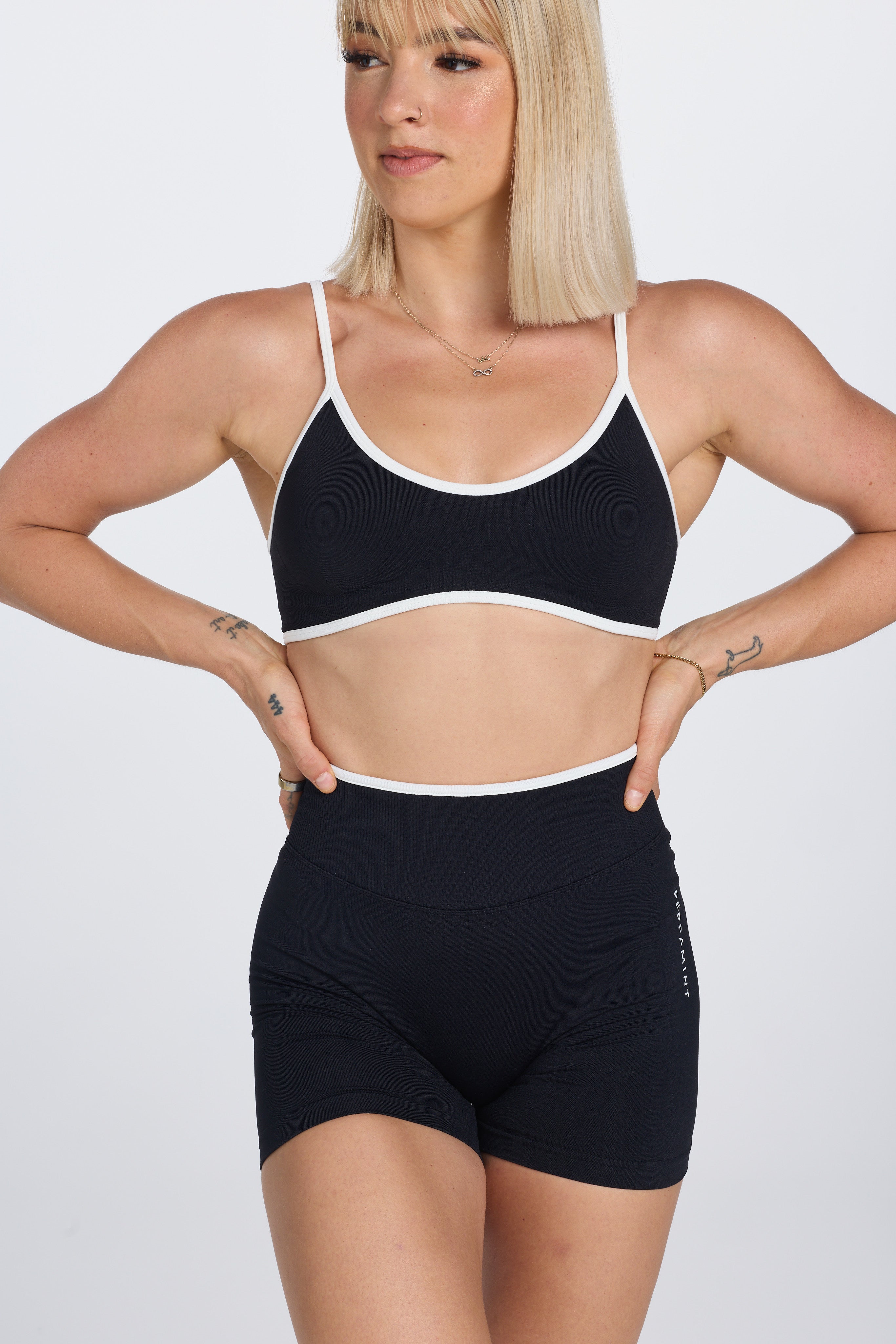 Seamless gym bra, with luxe white trim and adjustable back straps in black colour.