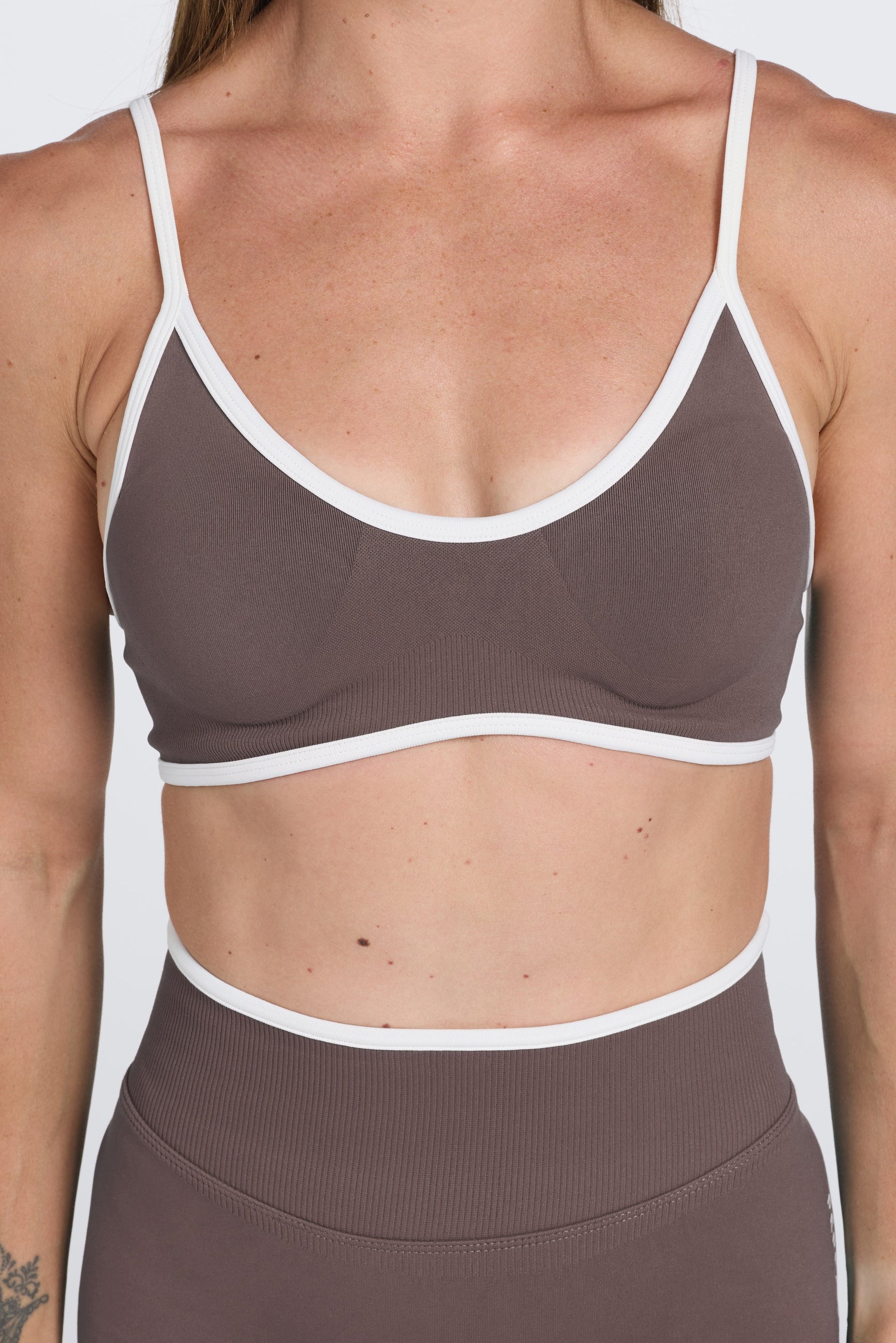 Seamless gym bra, with luxe white trim and adjustable back straps in Mocha.