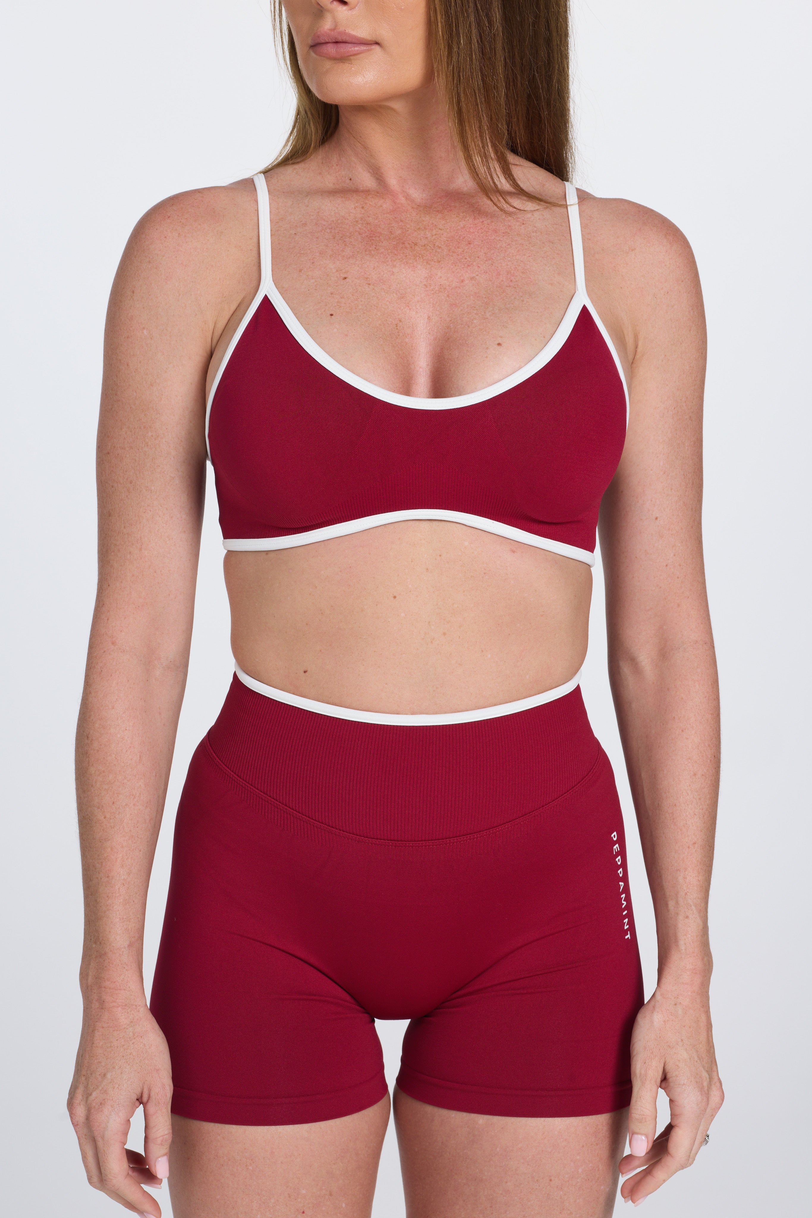 Seamless gym bra, with luxe white trim and adjustable back straps in wine colour.