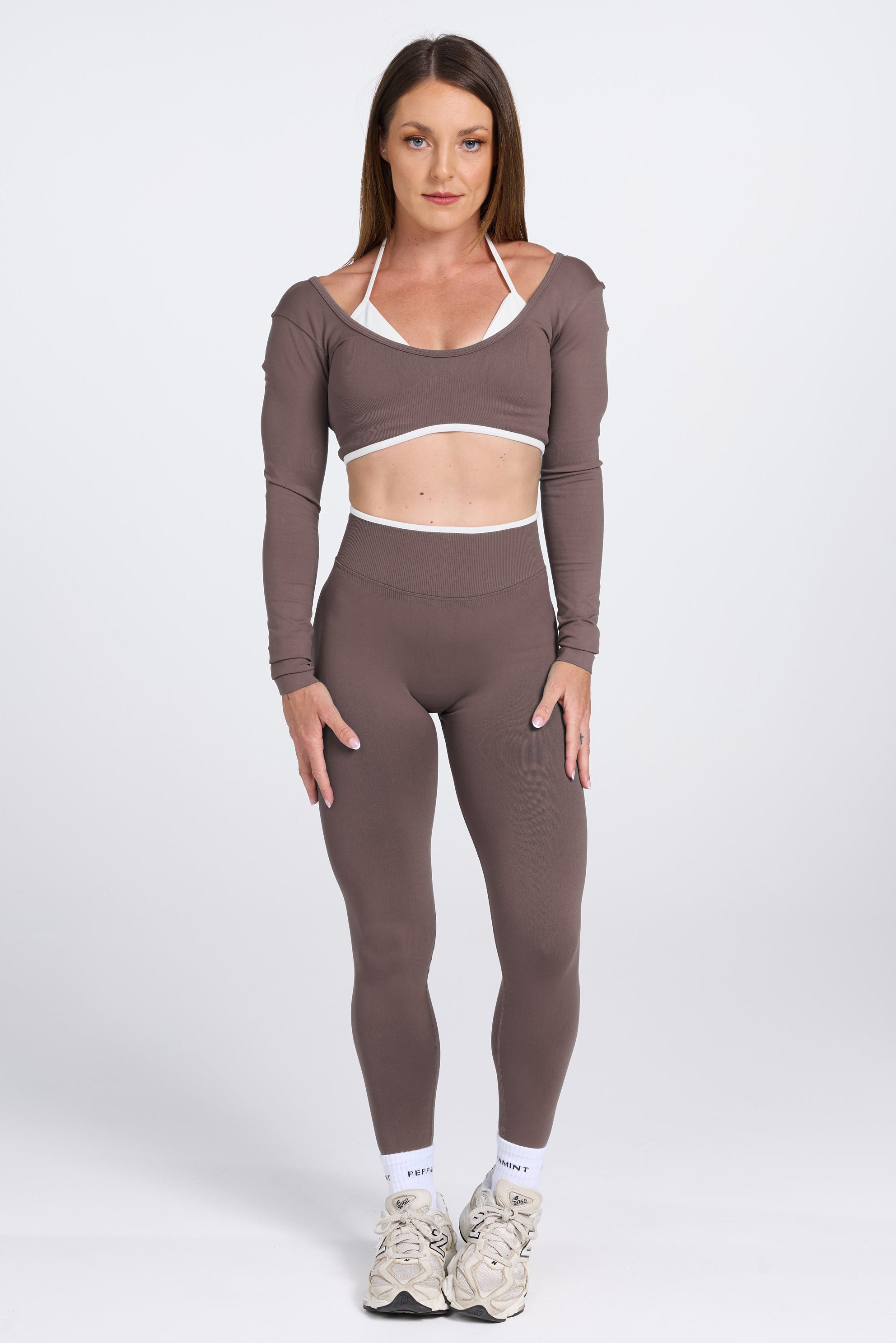 Long sleeve seamless crop top, with built in white contrasting bra, luxe white trim, and adjustable halter strap, with high waisted booty sculpting gym tights in Mocha.