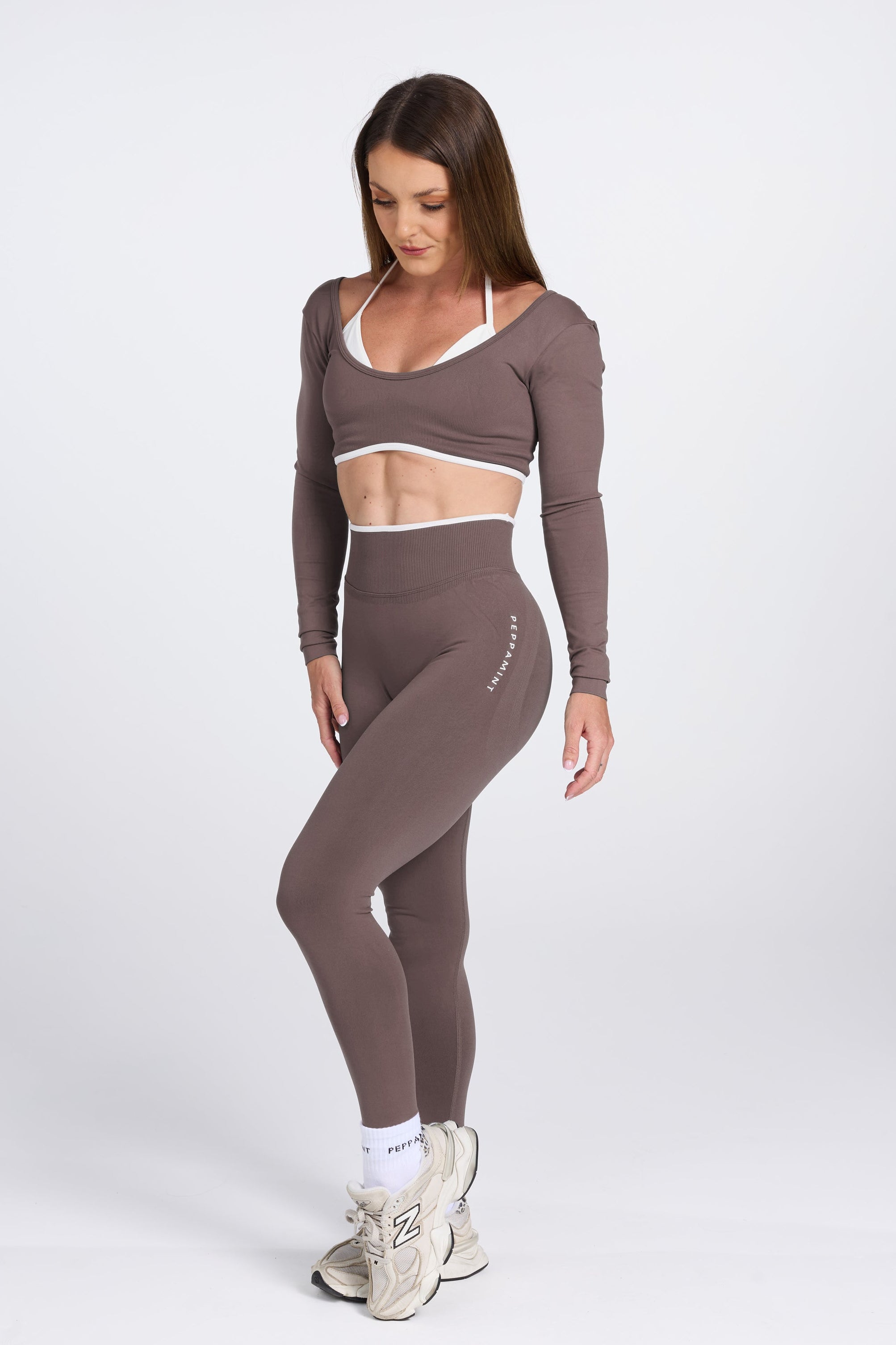 Long sleeve seamless crop top, with built in white contrasting bra, luxe white trim, and adjustable halter strap, with high waisted booty sculpting gym tights in Mocha.