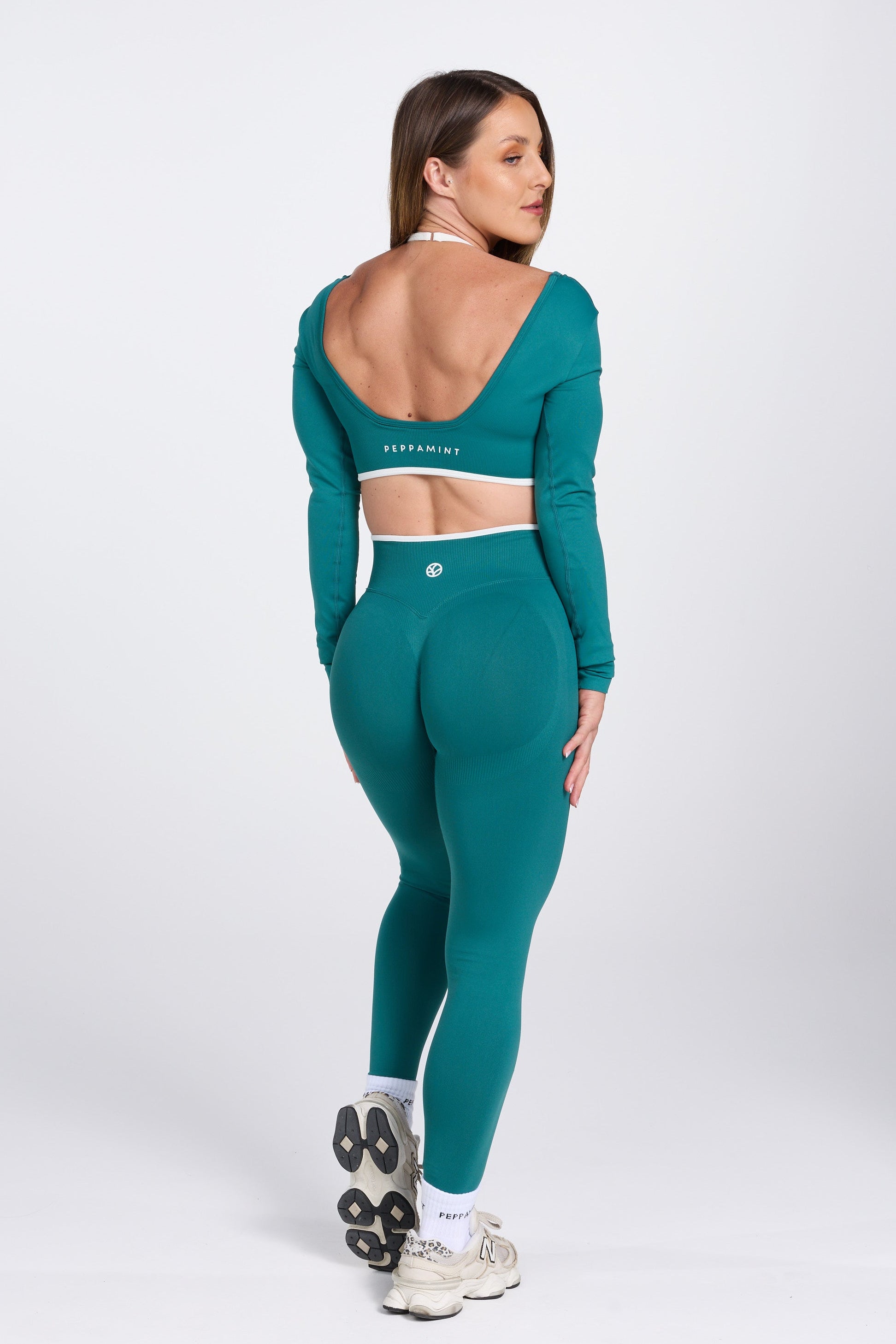 High waisted seamless gym tights, with textured booty sculpting panels, and a luxe white trim, in teal colour.