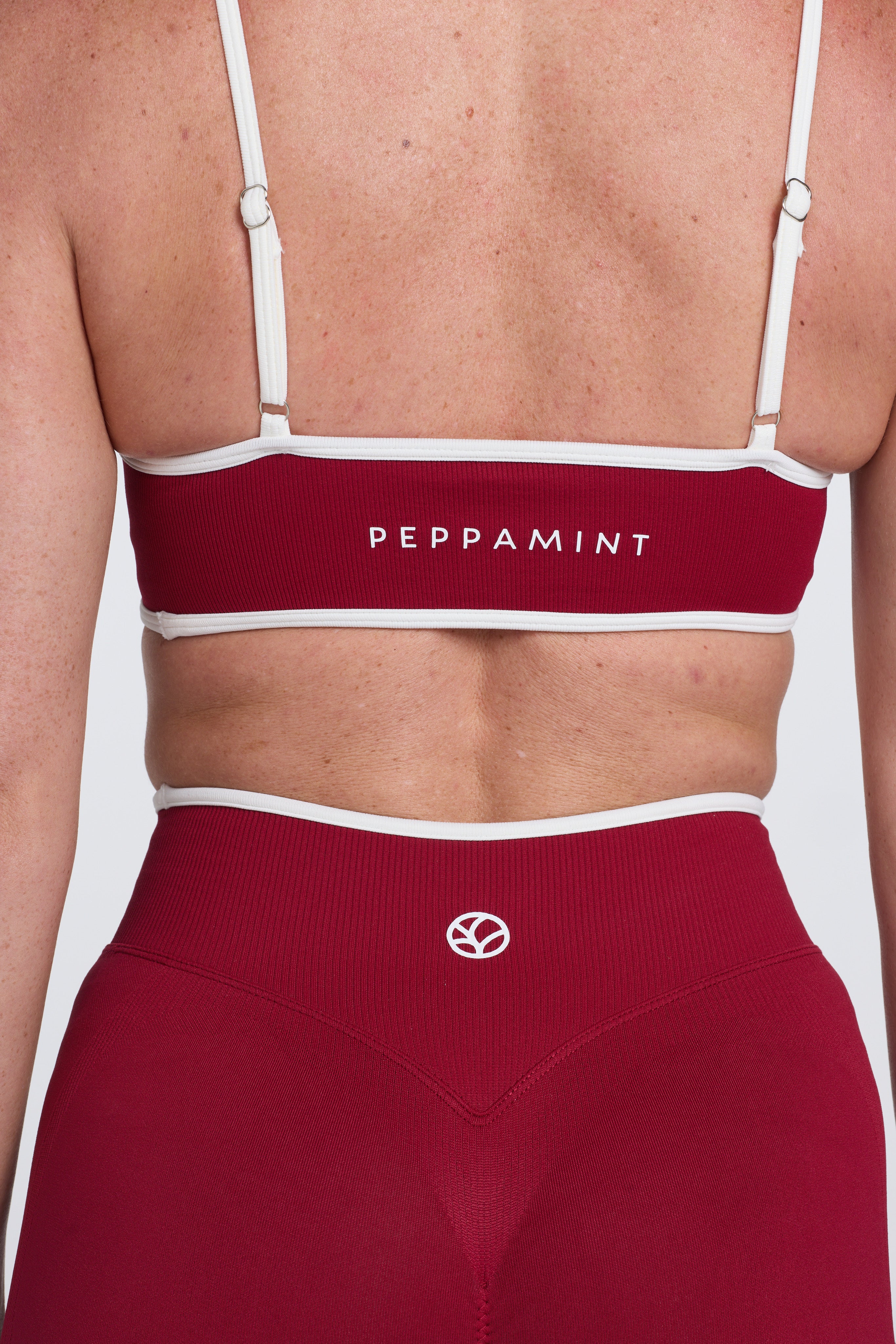 Seamless gym bra, with luxe white trim and adjustable back straps in wine colour.