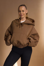 Load image into Gallery viewer, Oversize batwing hoodie, hip length, with slouchy oversized sleeves, piped seams, iconic ribbed panels and a kangaroo pocket with a hidden phone pocket inside in chocolate brown colour
