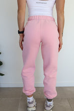 Load image into Gallery viewer, Fleece lined joggers in baby pink with elasticated waistband, drawstring, two side pockets and a subtle embossed logo icon on left pocket
