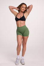 Load image into Gallery viewer, Minimalistic bra with breast contouring panels and a ruched front seam to effortlessly shape the breasts, with a sleek back straps and halter neck design in black and seamless gym tights with booty contouring panels, invisible scrunch technology, sweetheart shaped back seams and thick supportive fabric in mermaid green colour
