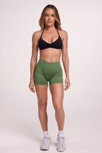 Load image into Gallery viewer, Minimalistic bra with breast contouring panels and a ruched front seam to effortlessly shape the breasts, with a sleek back straps and halter neck design in black and seamless gym tights with booty contouring panels, invisible scrunch technology, sweetheart shaped back seams and thick supportive fabric in mermaid green colour
