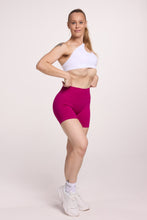 Load image into Gallery viewer, Front cross over strap activewear bra in seamless fabric with adjustable back straps, and ribbed supportive underbust band in white and seamless gym tights with booty contouring panels, invisible scrunch technology, sweetheart shaped back seams and thick supportive fabric in magenta pink
