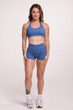 Load image into Gallery viewer, Seamless halter bra with a thick supportive fabric blend and a branded back strap, with a ribbed elastic hem and seamless shorts with booty contouring panels, invisible scrunch technology, a sweetheart shaped back seam, and a thick supportive waistband in grey blue colour
