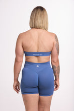 Load image into Gallery viewer, Seamless halter bra with a thick supportive fabric blend and a branded back strap, with a ribbed elastic hem and seamless shorts with booty contouring panels, invisible scrunch technology, a sweetheart shaped back seam, and a thick supportive waistband in grey blue colour
