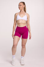 Load image into Gallery viewer, Minimalistic bra with breast contouring panels and a ruched front seam to effortlessly shape the breasts, with a sleek back straps and halter neck design in white and seamless gym tights with booty contouring panels, invisible scrunch technology, sweetheart shaped back seams and thick supportive fabric in magenta colour
