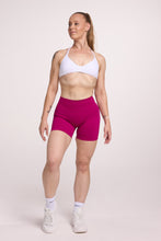 Load image into Gallery viewer, Minimalistic bra with breast contouring panels and a ruched front seam to effortlessly shape the breasts, with a sleek back straps and halter neck design in white and seamless gym tights with booty contouring panels, invisible scrunch technology, sweetheart shaped back seams and thick supportive fabric in magenta colour
