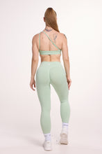Load image into Gallery viewer, Front cross over strap activewear bra in seamless fabric with adjustable back straps, and ribbed supportive under bust band with seamless gym tights with booty contouring panels, invisible scrunch technology, sweetheart shaped back seams and thick supportive fabric in mist green
