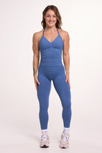 Load image into Gallery viewer, Halter neck tank top with breast contouring panels and a ruched front seam, a built in bra, and an open upper back design and seamless gym tights with booty contouring panels, invisible scrunch technology, sweetheart shaped back seams and thick supportive fabrics in grey blue colour
