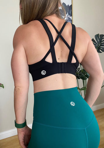 Moderate to high support impact sports bra in black, with adjustable clasp back, cross straps and build in bra pads. 