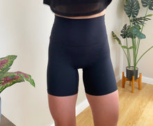 Load image into Gallery viewer, Mid length shorts in black with thick brushed fabric, with seamless front rise, extra high waistband waistband and silicon subtle logo
